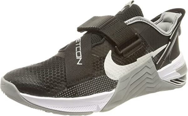 La imagen muestra un par de zapatillas de entrenamiento NIKE Metcon 7 Flyease en color gris y negro con un diseño Flyease para un fácil encendido y apagado. Estas zapatillas son ideales para el entrenamiento de alta intensidad y el CrossFit.